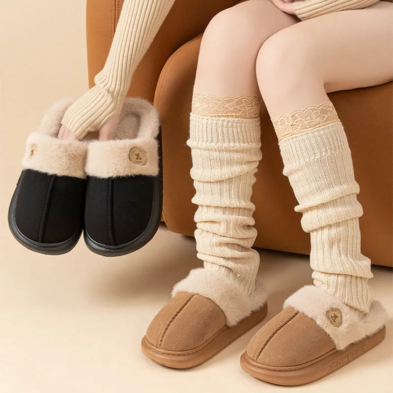 Pair of thick-soled plush fleece slippers in brown with car stitching detail on the upper.