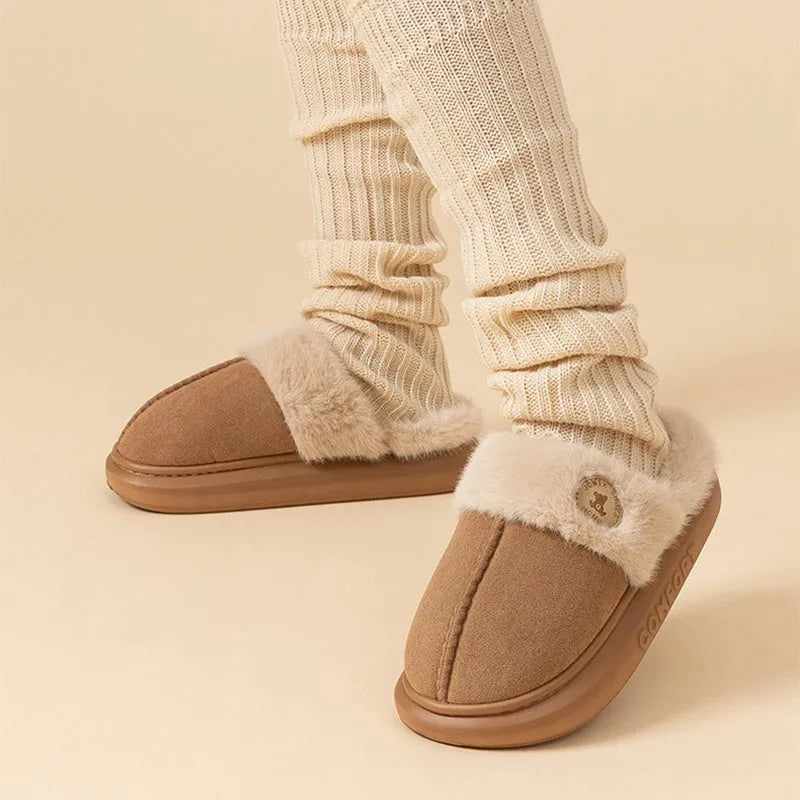 Pair of thick-soled plush fleece slippers in brown with car stitching detail on the upper.