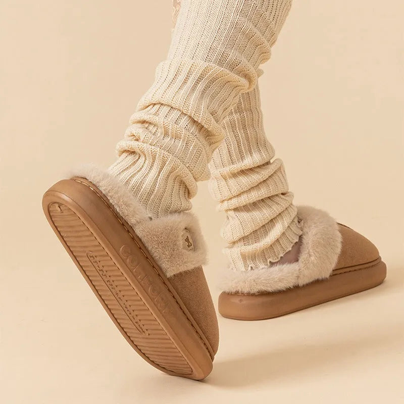 Pair of thick-soled plush fleece slippers in brown with car stitching detail on the upper.
