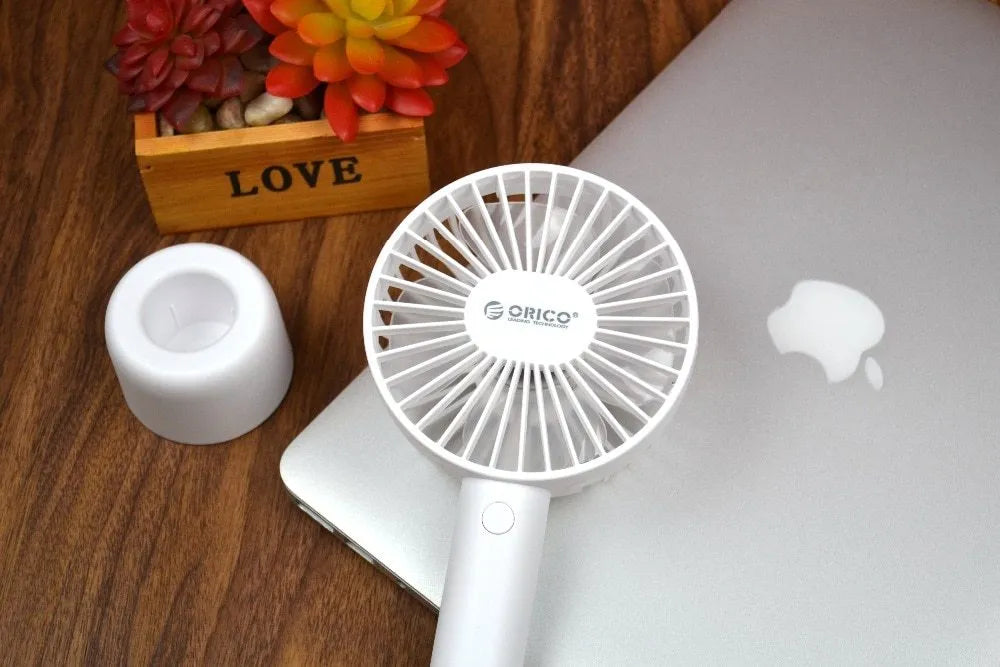 White ORICO FH1 portable USB desk fan with fine-line texture, shown as a handheld and desktop unit.