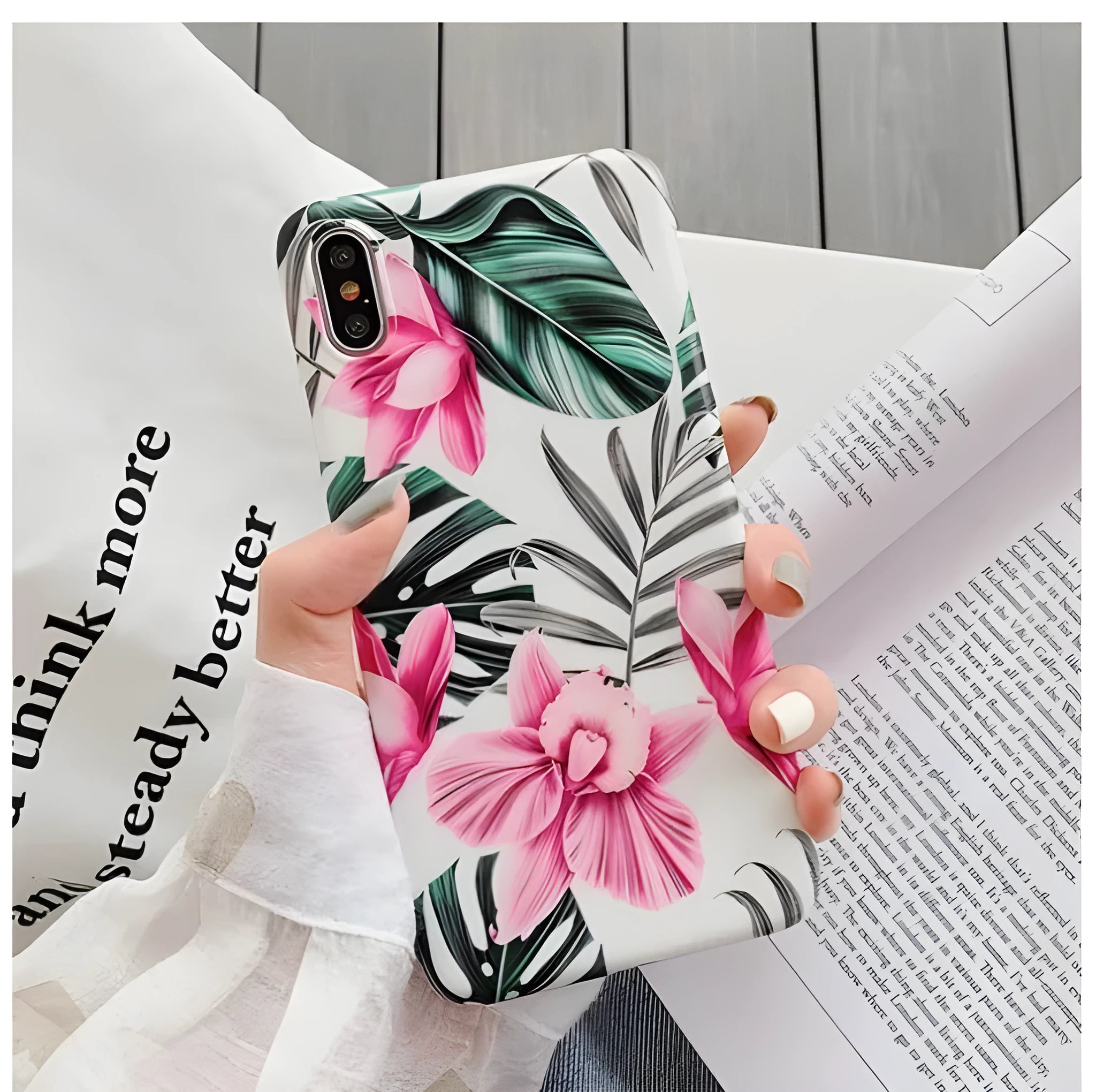 Pink floral pattern TPU back cover case for iPhone on a table.