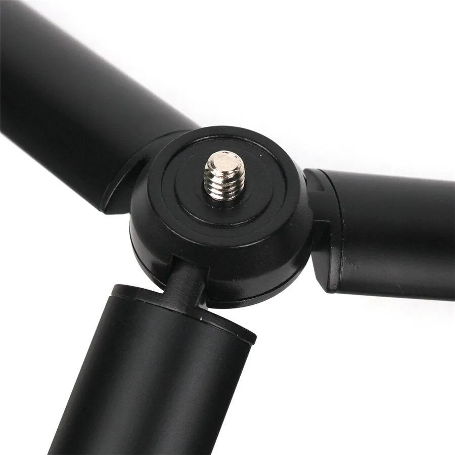 Black aluminium mobile phone tripod stabilizer with PTZ functionality on a table