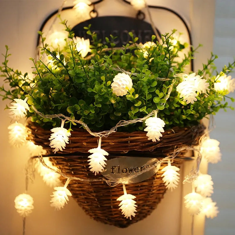 Battery-powered LED light string with plastic pine cone shells, shown in warm white and colour options.
