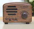 Vintage wood Bluetooth speaker in black, pink and wood grain colours showing compact design