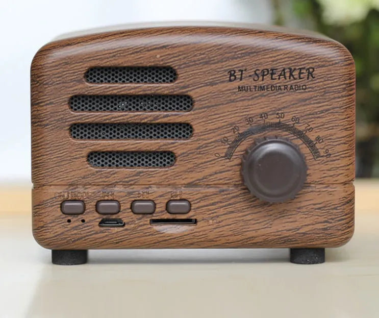 Vintage wood Bluetooth speaker in black, pink and wood grain colours showing compact design