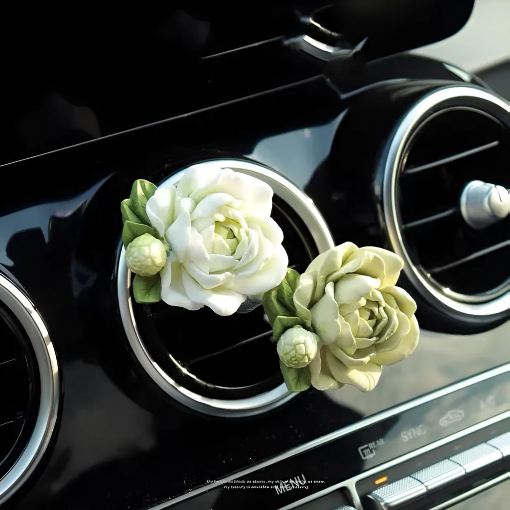 Jasmine scented gypsum solid car perfume clipped to a car air vent in off white or fresh green.