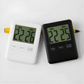 Black and white digital kitchen timer with magnet back on a refrigerator