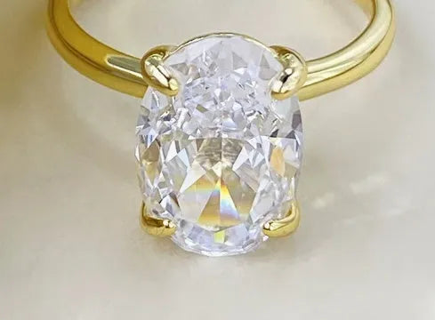 Oval women's ring with four-claw setting holding a 6x9mm gemstone on a silver band