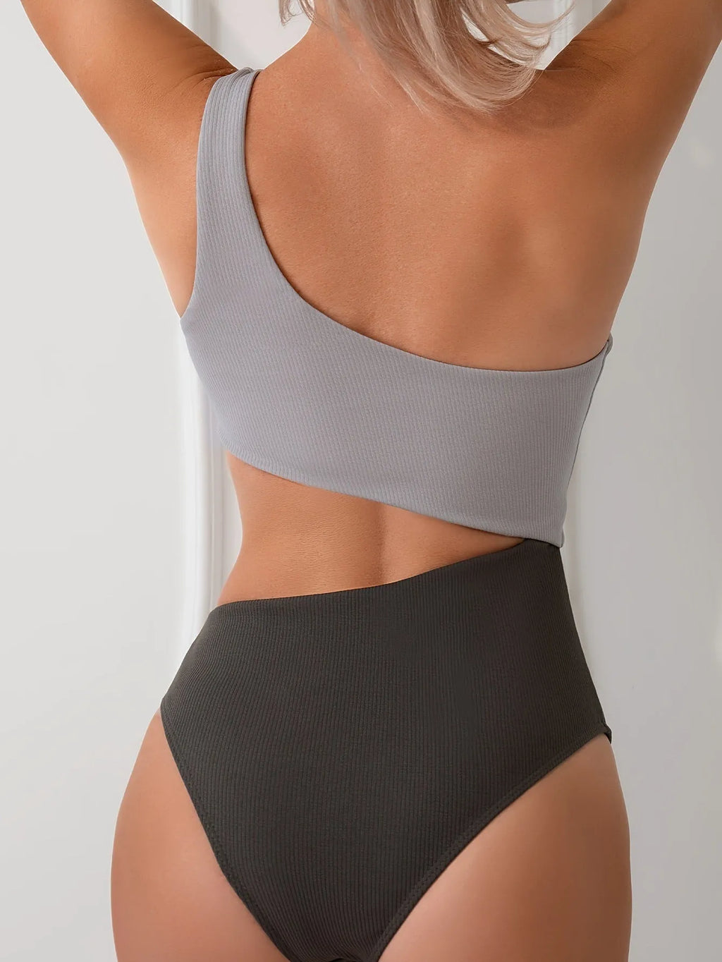 Women's light grey one-shoulder one-piece swimsuit on a white background