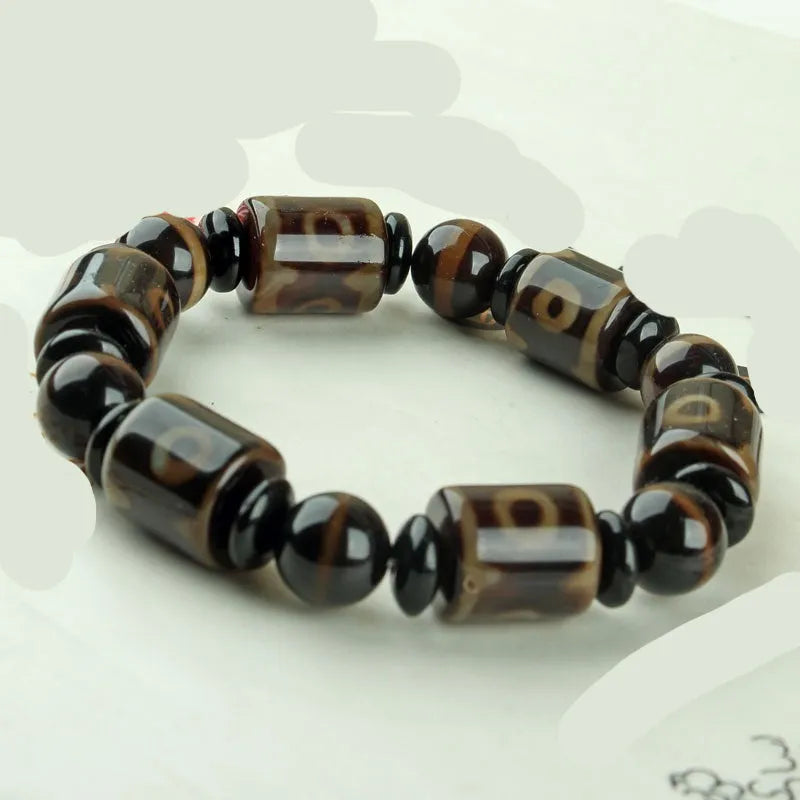 Distressed agate bracelet with traditional Tibetan dzi beads including three-eye and Nine Eyes designs.