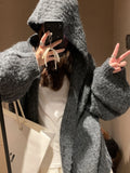 Women's dark grey loose-fit hooded acrylic sweater cardigan on a hanger
