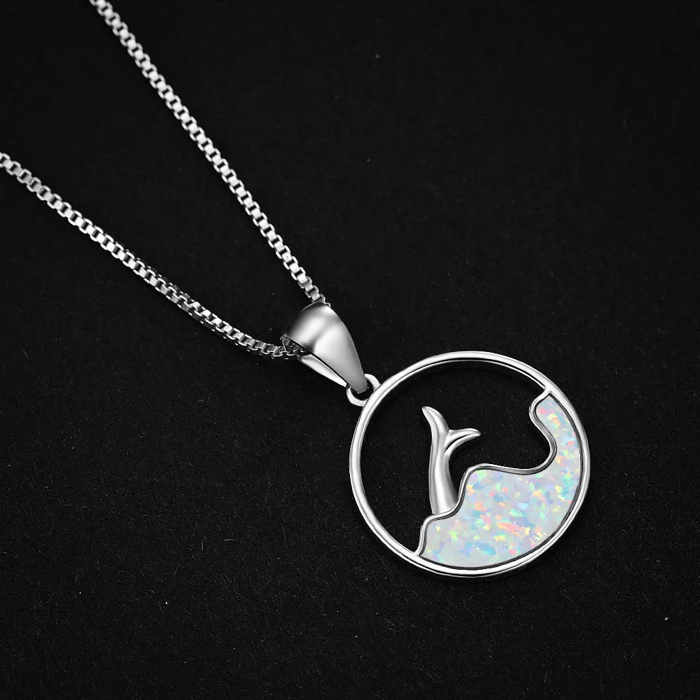 White gold colour electroplated necklace with a round sea fishtail pendant featuring a blue opal stone.