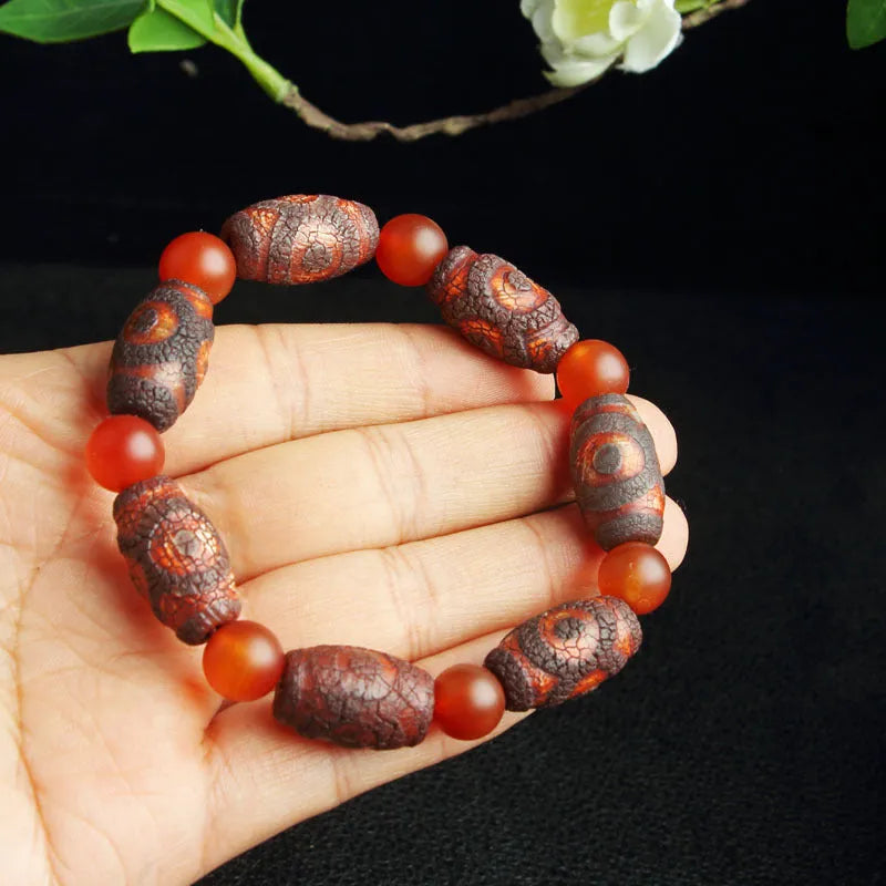 Distressed agate bracelet with traditional Tibetan dzi beads including three-eye and Nine Eyes designs.