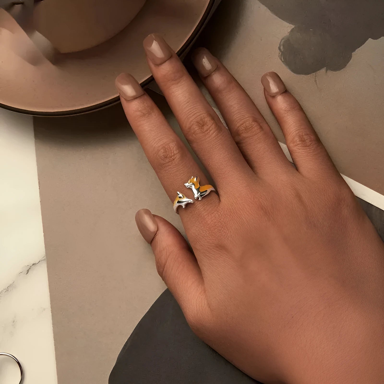 Cartoon-style silver corgi dog ring on a plain background.