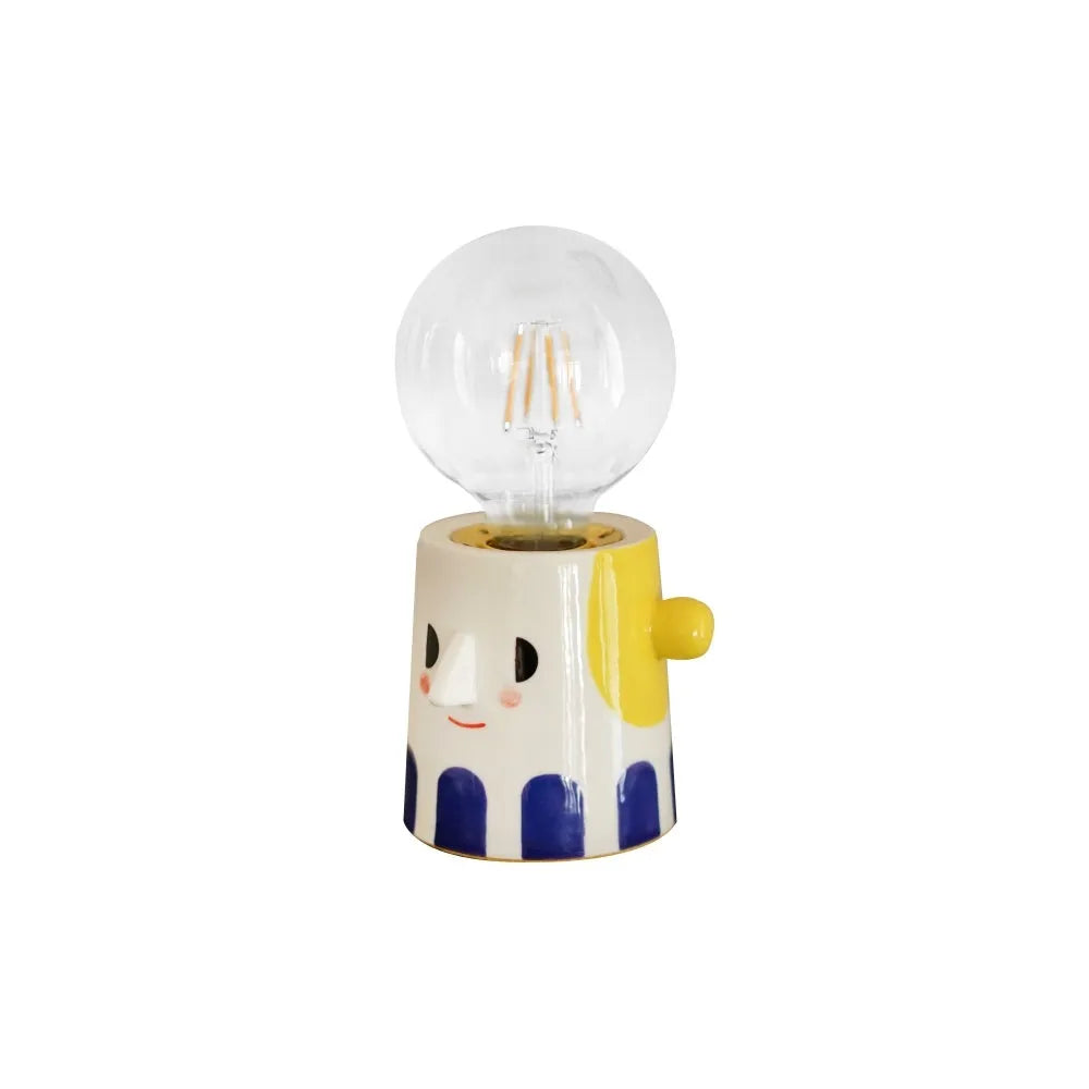 Handmade ceramic ball headlight bedside lamp on a table.