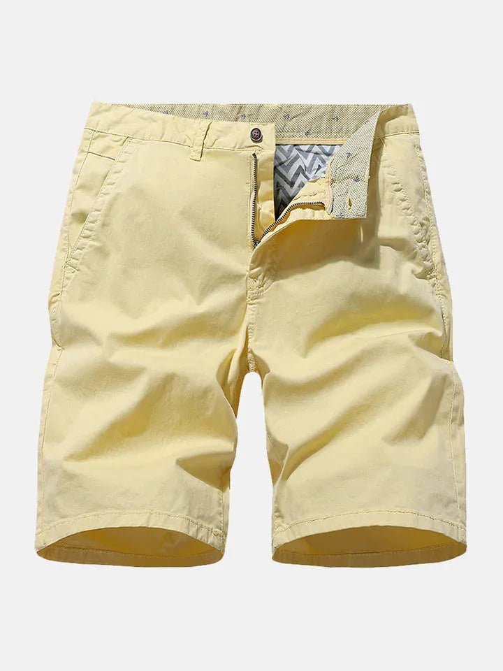 Men's loose-fit printed denim shorts in blue, shown in a casual setting.