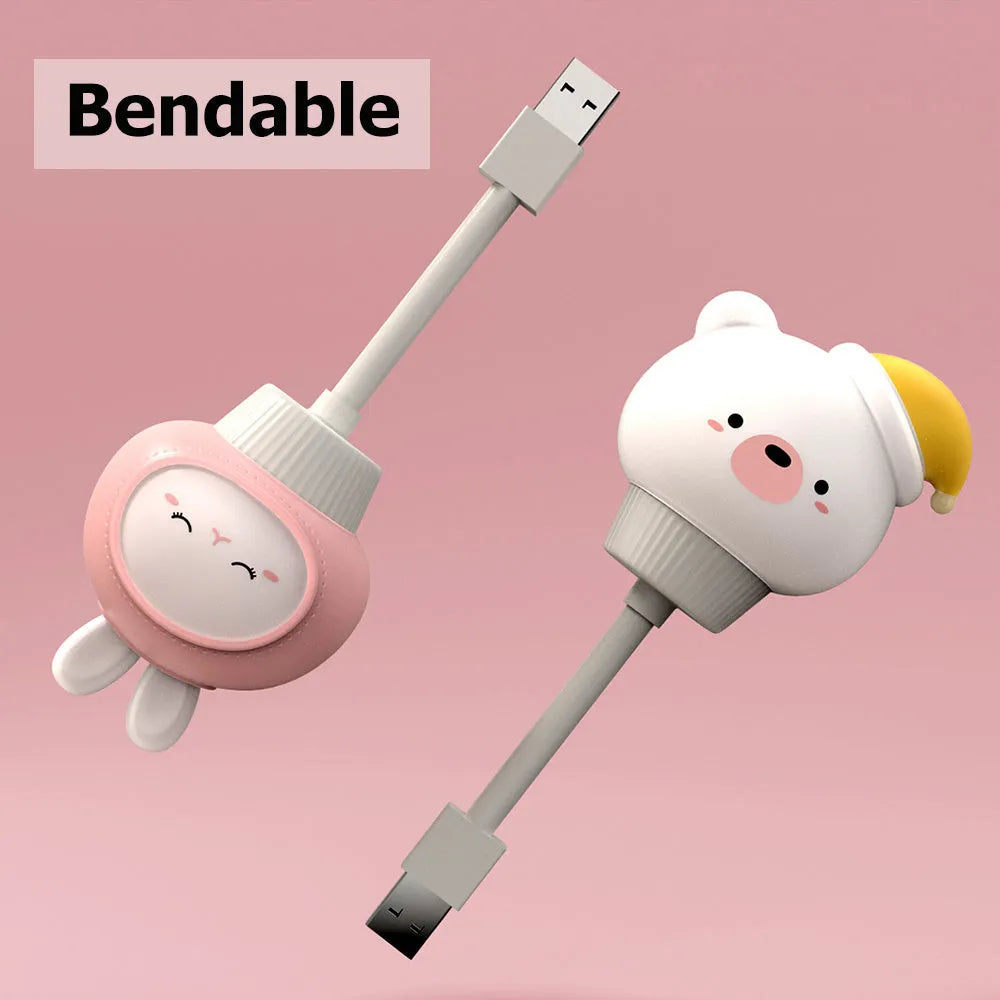 Cartoon animal USB night light with remote control on a bedside table.