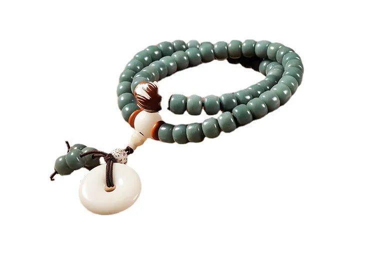 White and green beaded bracelet with a double ring safety buckle and a prominent double ring lotus bead decoration.