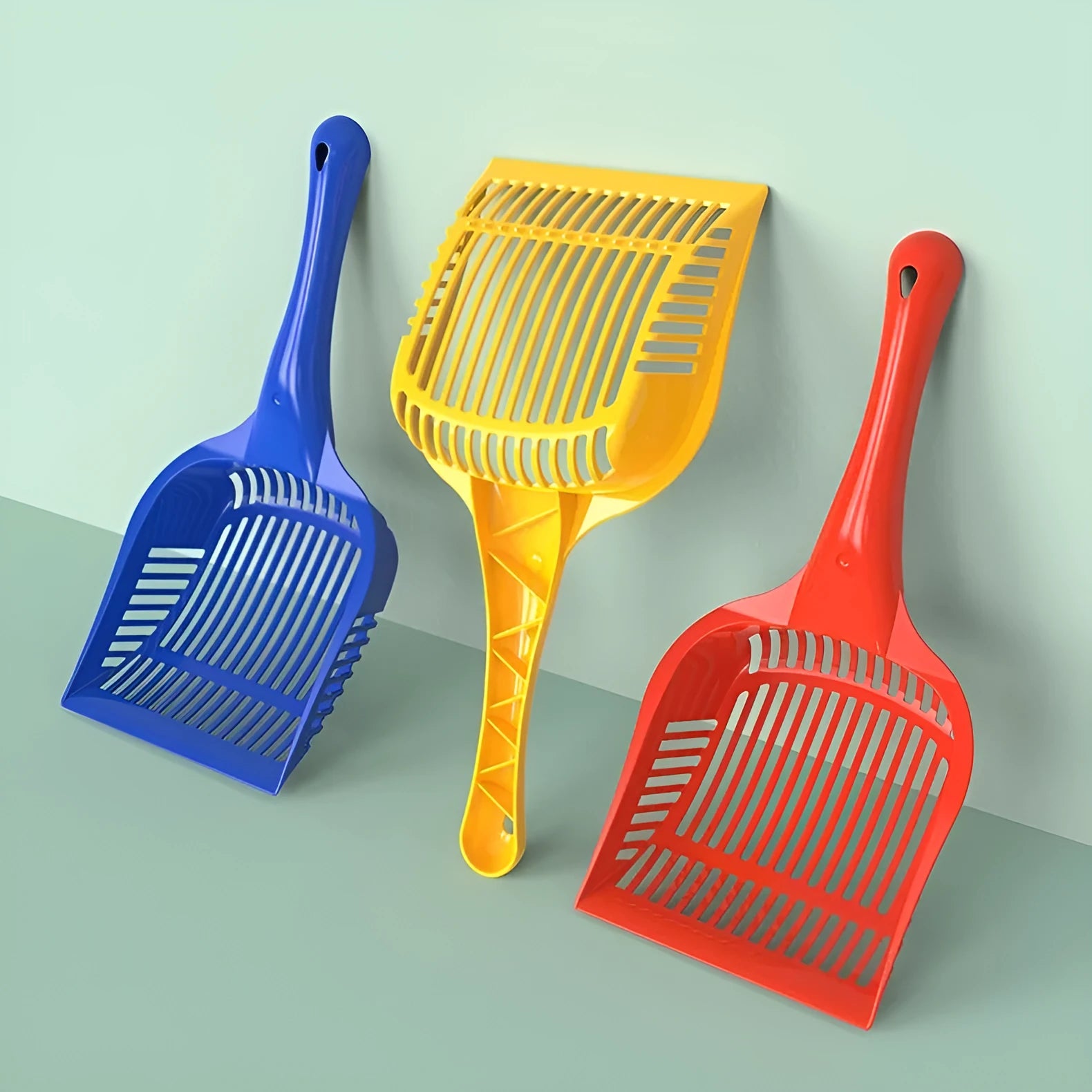 Red, yellow, and blue plastic cat litter scoops in small and medium sizes on a white background.