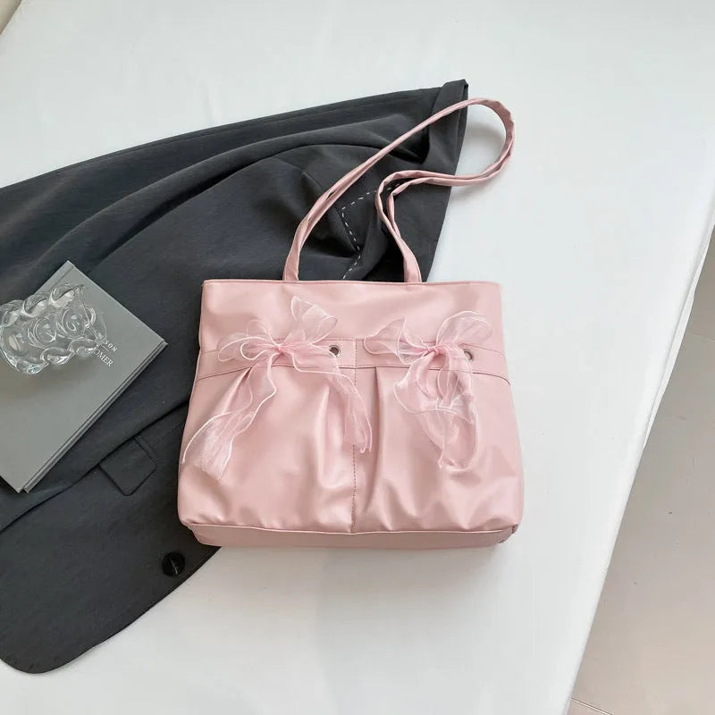 Black college style bow tote bag with double shoulder straps and large main compartment