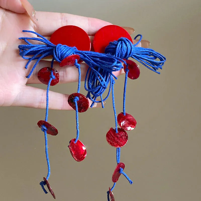 Women's geometric earrings with blue resin flower and silver needle on cloth background