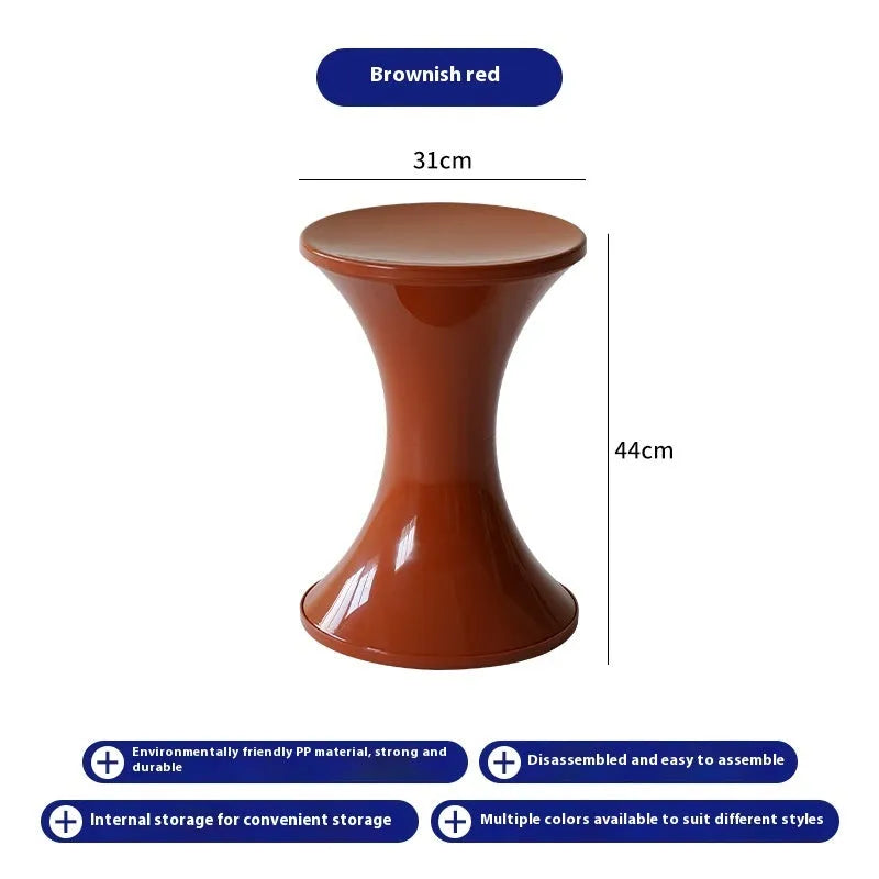 A plastic hourglass-shaped stool for changing shoes, shown in a green colour variant.