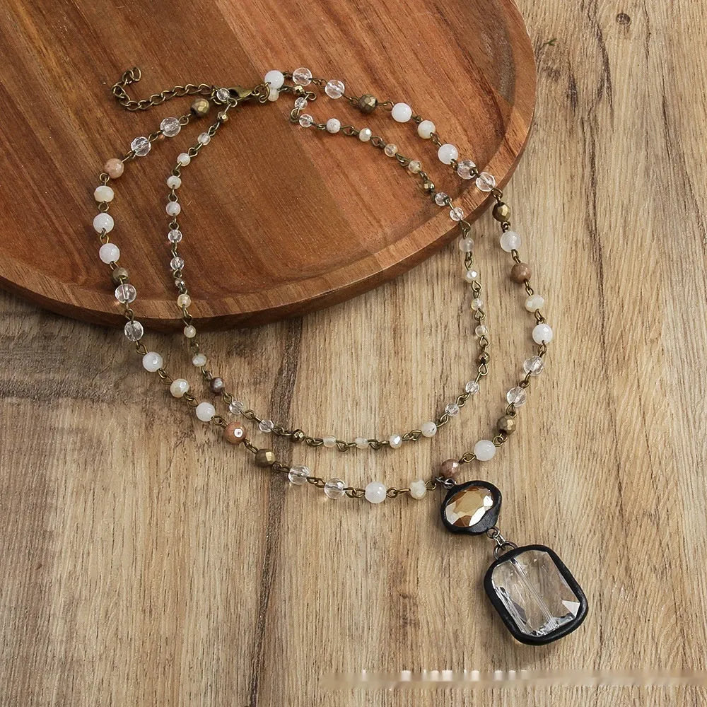 Two-layer tribal-style chain necklace with glass pendant and stone elements in beige and blue colour options