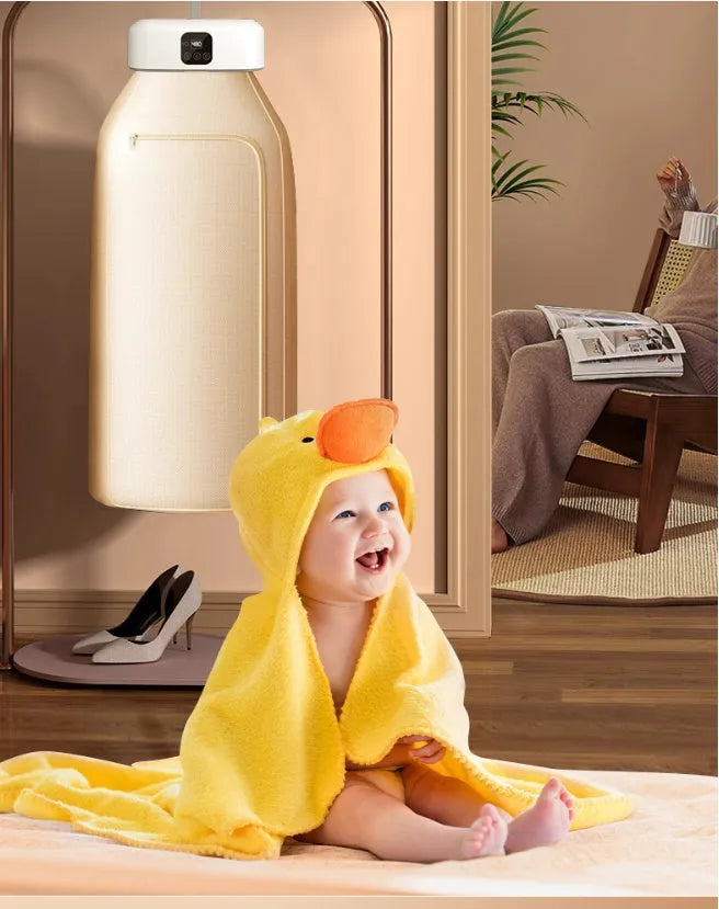 White cylindrical foldable clothes dryer with remote control on a table.