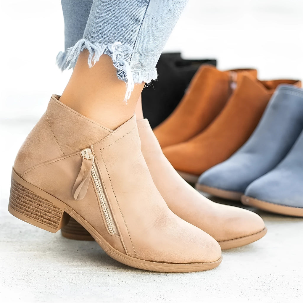 Women's beige suede ankle boots with a side zip and a chunky block heel.