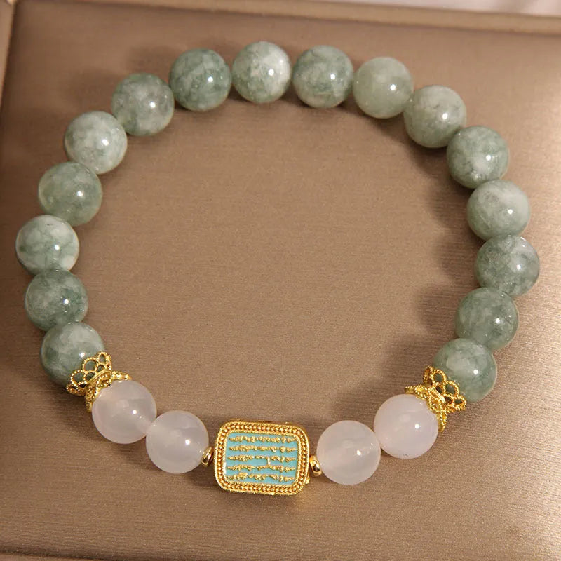 Women's oil green emerald crystal bracelet with five scriptures design on a wrist.