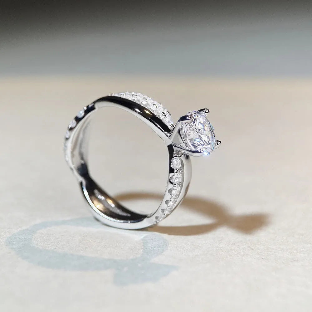 Geometric cross design moissanite ring with twisted sterling silver band and four-claw setting.