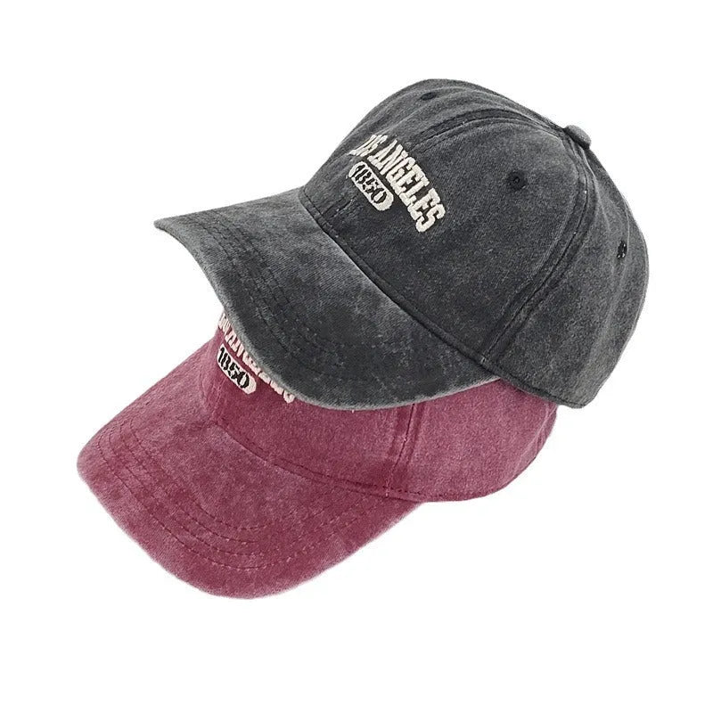 Retro personalised washed distressed embroidered peaked cap in beige colour on a wooden background