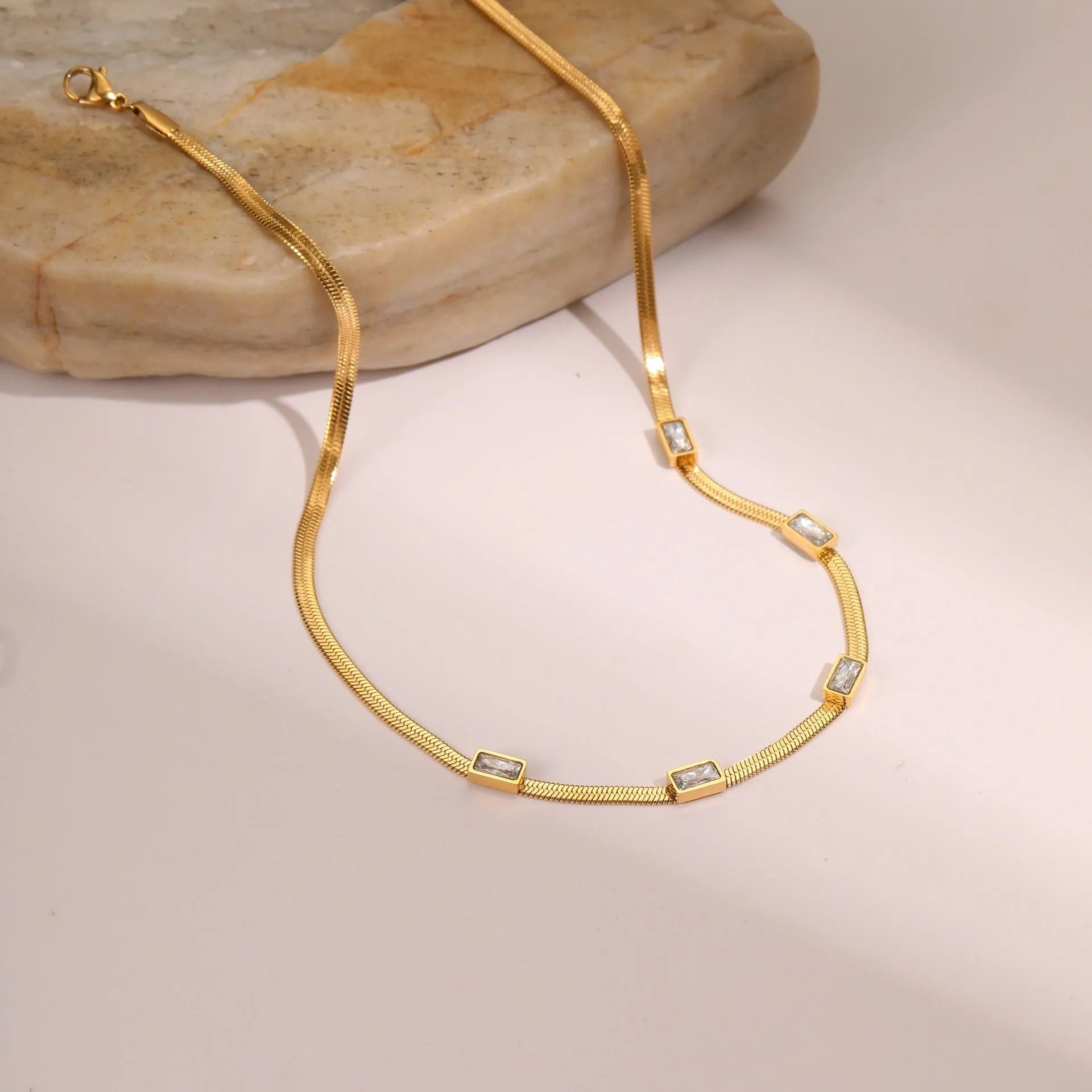 Retro geometric square zircon pendant on a stainless steel flat snake necklace chain.