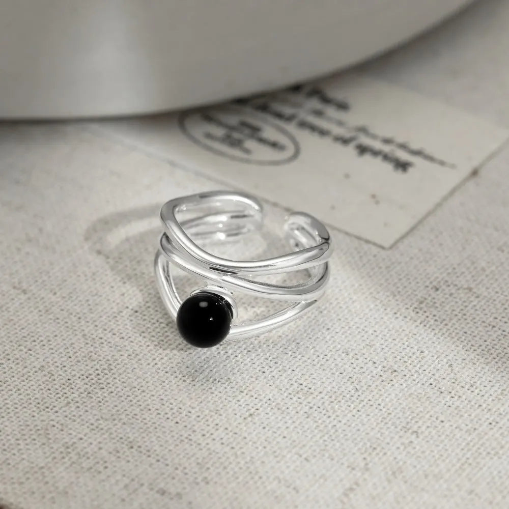 S925 sterling silver women's ring with inlaid black agate, multi-line hollow geometric design, adjustable open band.
