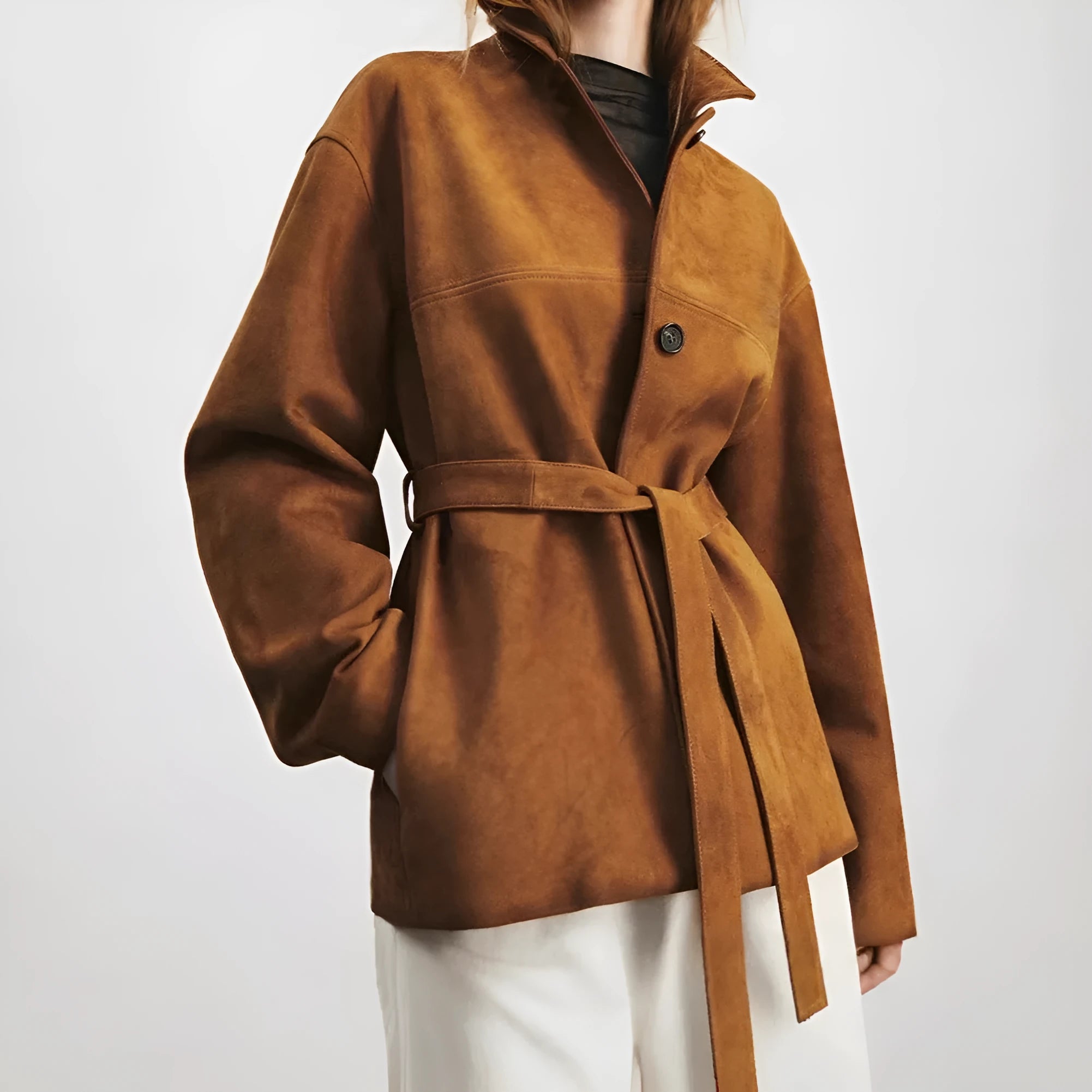 Yellow brown retro-style leather cashmere coat with Peter Pan collar and belt on a hanger.
