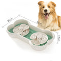 Large green slow feeder dog bowl with wave-pattern trays and suction cups on a wooden floor.