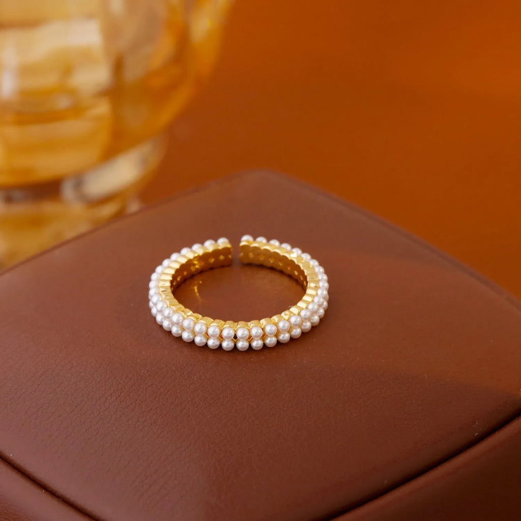 Gold coloured open mouth ring with geometry modelling and round design elements on copper base