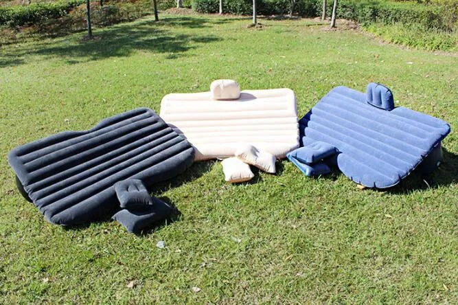 Black inflatable car bed with flocked texture, shown with two pillows inside a car.