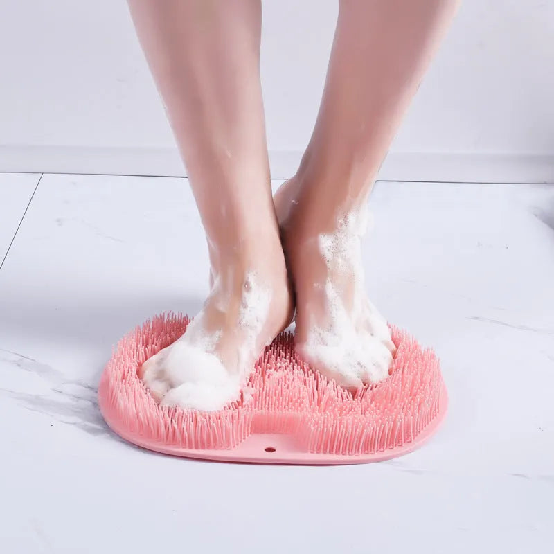 Orange silicone bristle massage bath brush with suction cup bottom on bathroom floor