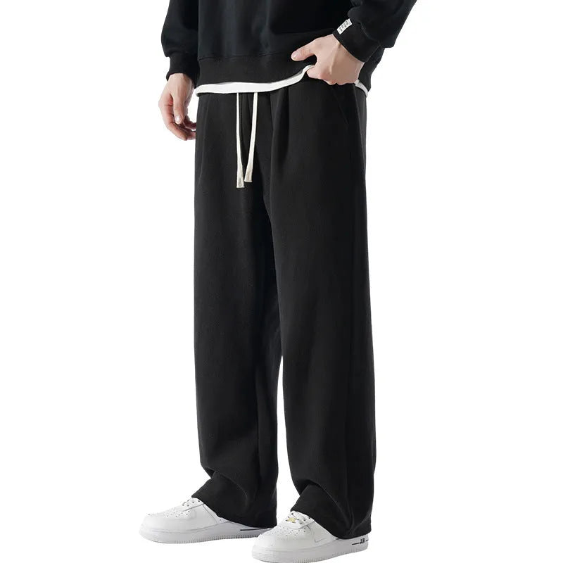 Man wearing loose apricot fleece-lined sports trousers with a drawstring waistband.