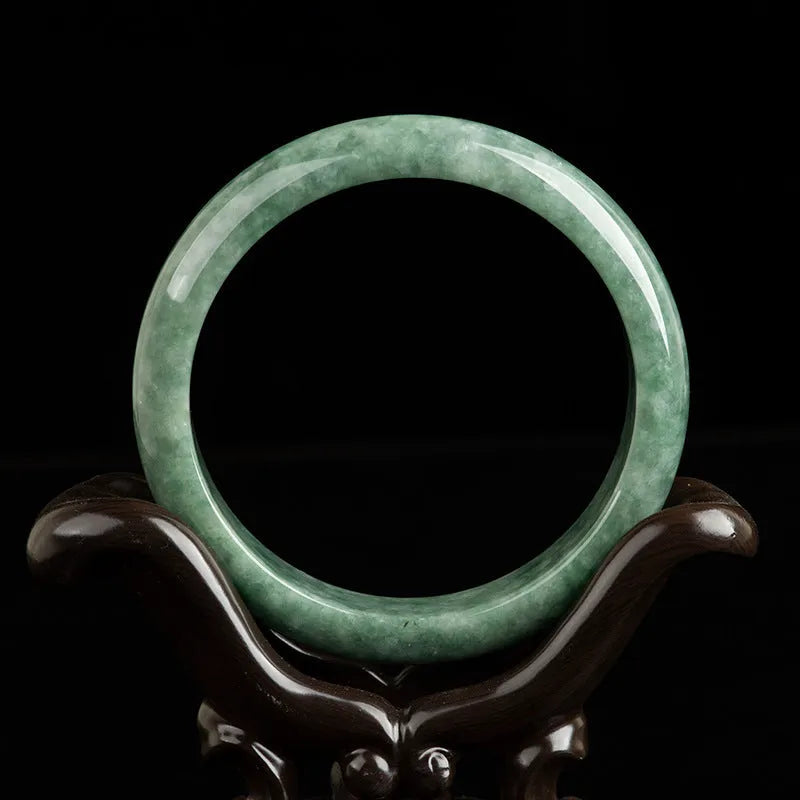 Natural emerald green stone bracelet for women on a wrist, presented with its certificate and gift box.