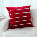 Square striped velvet plush cushion cover in a selection of colours on a sofa.