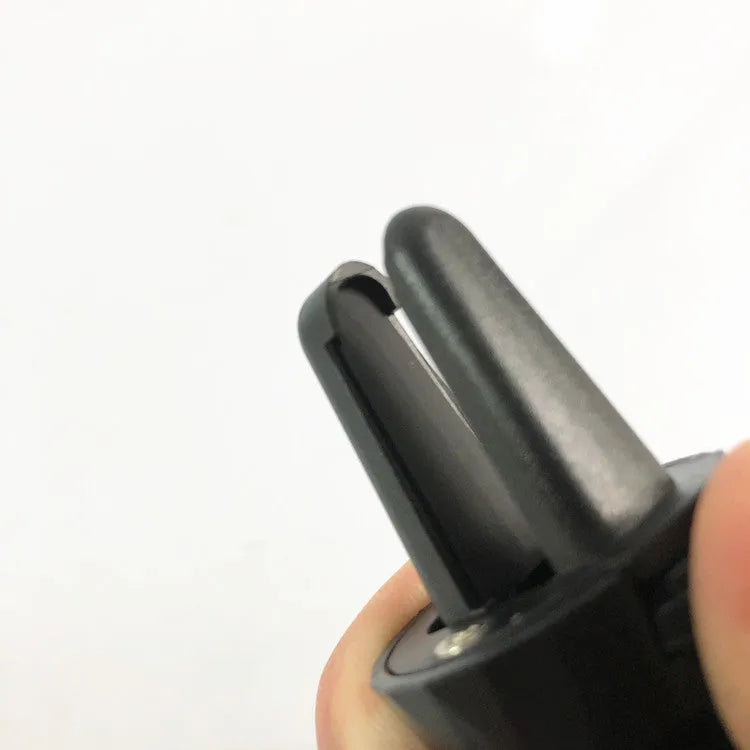 Black car phone holder mounted on car air vent with phone in adjustable clamp