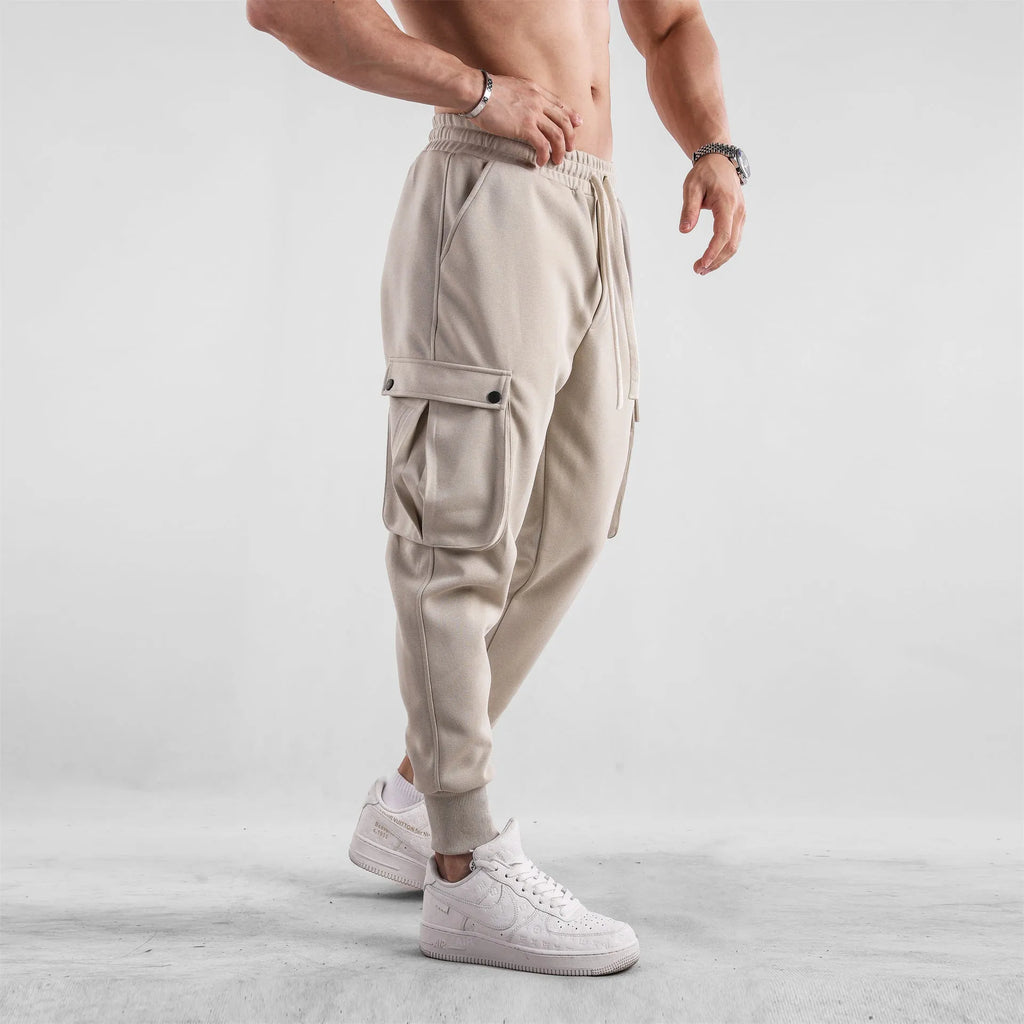 Men's loose cotton sports trousers with ankle tie closure and multiple pockets in solid colour