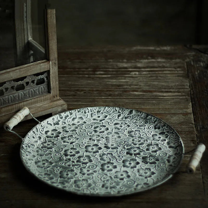 Round European wrought iron belt storage tray in two size options on a wooden surface.