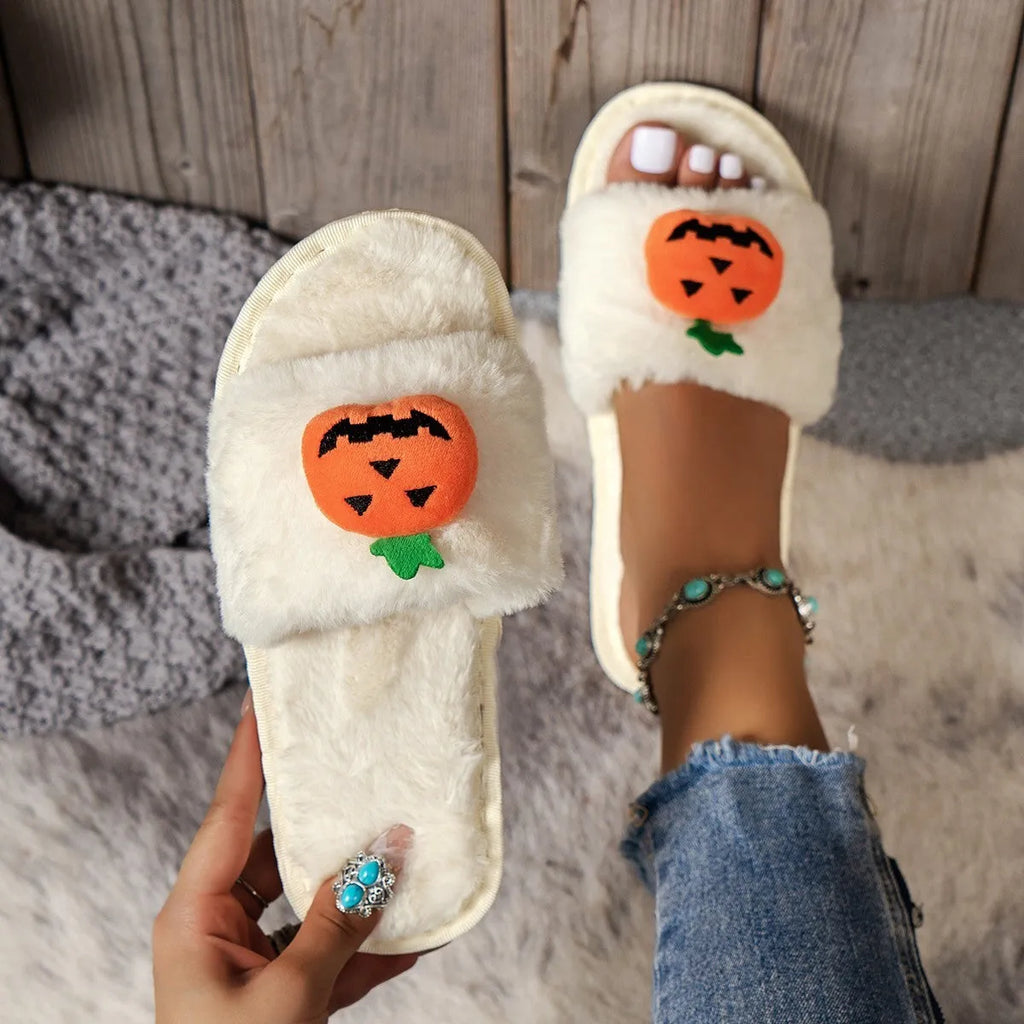 Yellow pumpkin plush open-toe slippers with a cartoon face, shown on a white background.