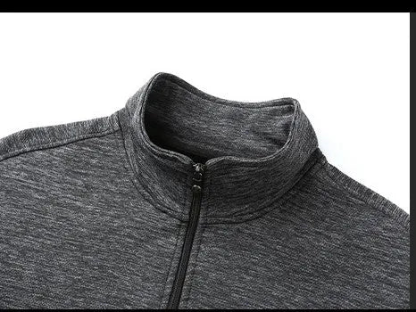 Man wearing a grey athletic fit jacket with a standing collar and front zipper.