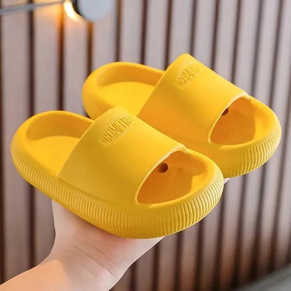 Children's bright coloured EVA slippers with textured non-slip soles, shown in blue, green, orange, pink, and yellow.