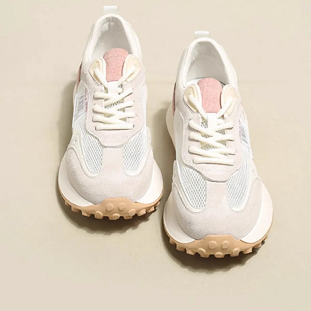 Grey and pink women's low-top retro sneaker with round toe and rubber sole on a white background.