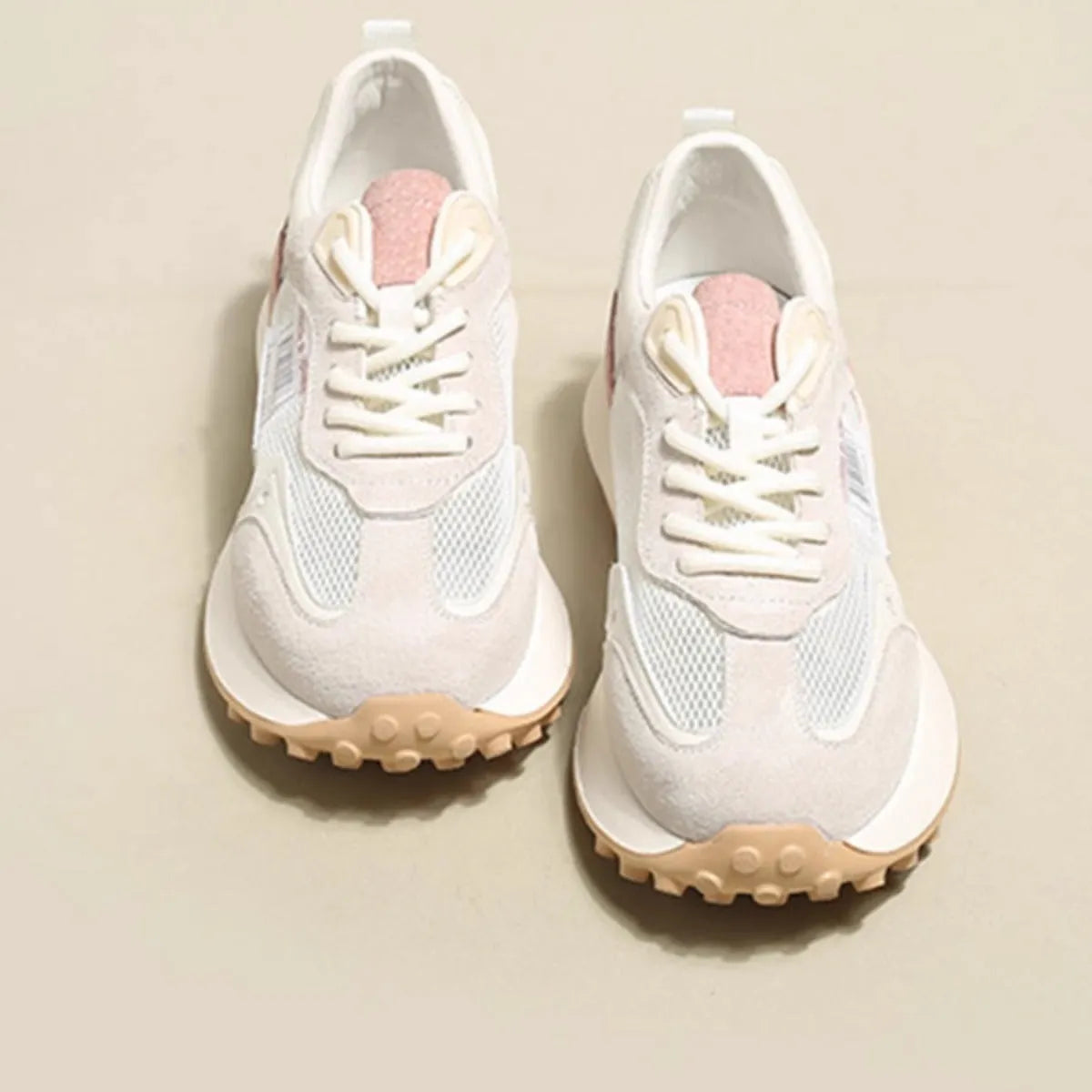 Grey and pink women's low-top retro sneaker with round toe and rubber sole on a white background.